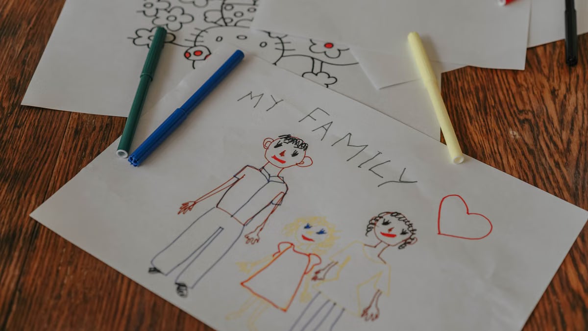 A hand-drawn family portrait using colored markers on paper, showcasing creativity and love.